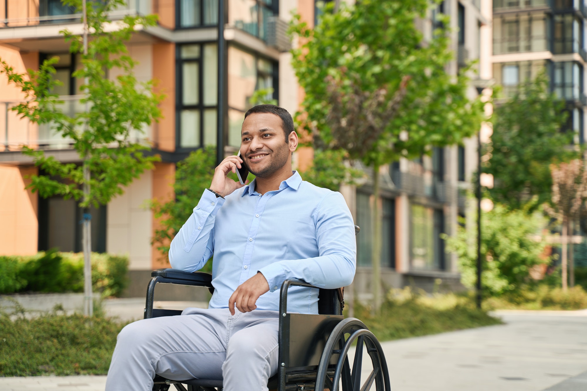 Cheerful disabled male person talking on cellphone