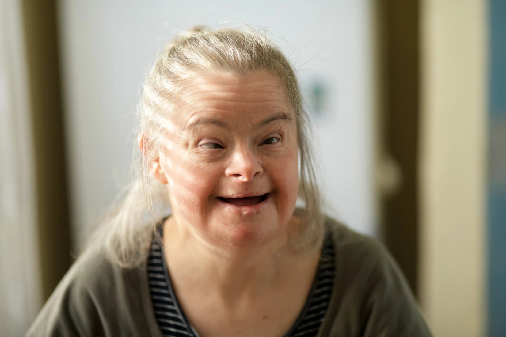 Woman with down syndrome smiling at camera