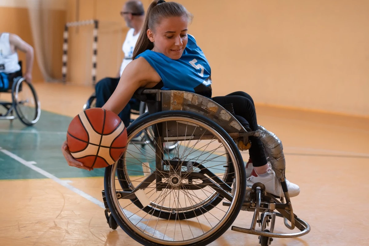 Disabled woman in wheelchair playing basketball