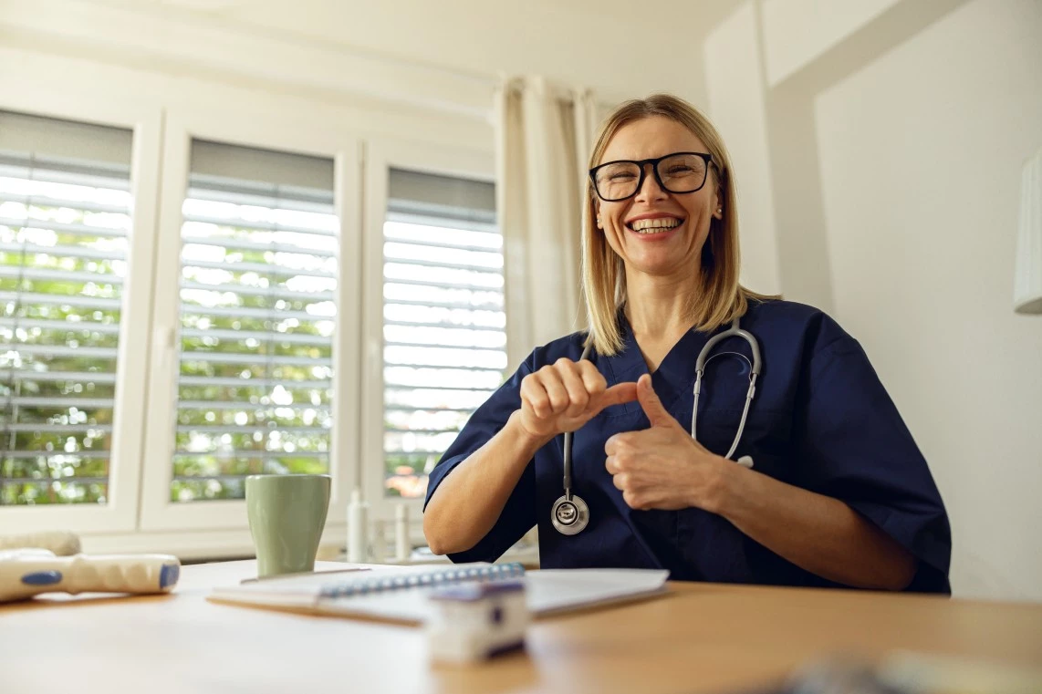 Smiling nurse using sign language