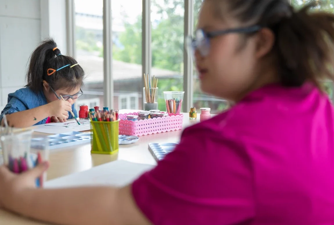 Two disabled friends in an art class