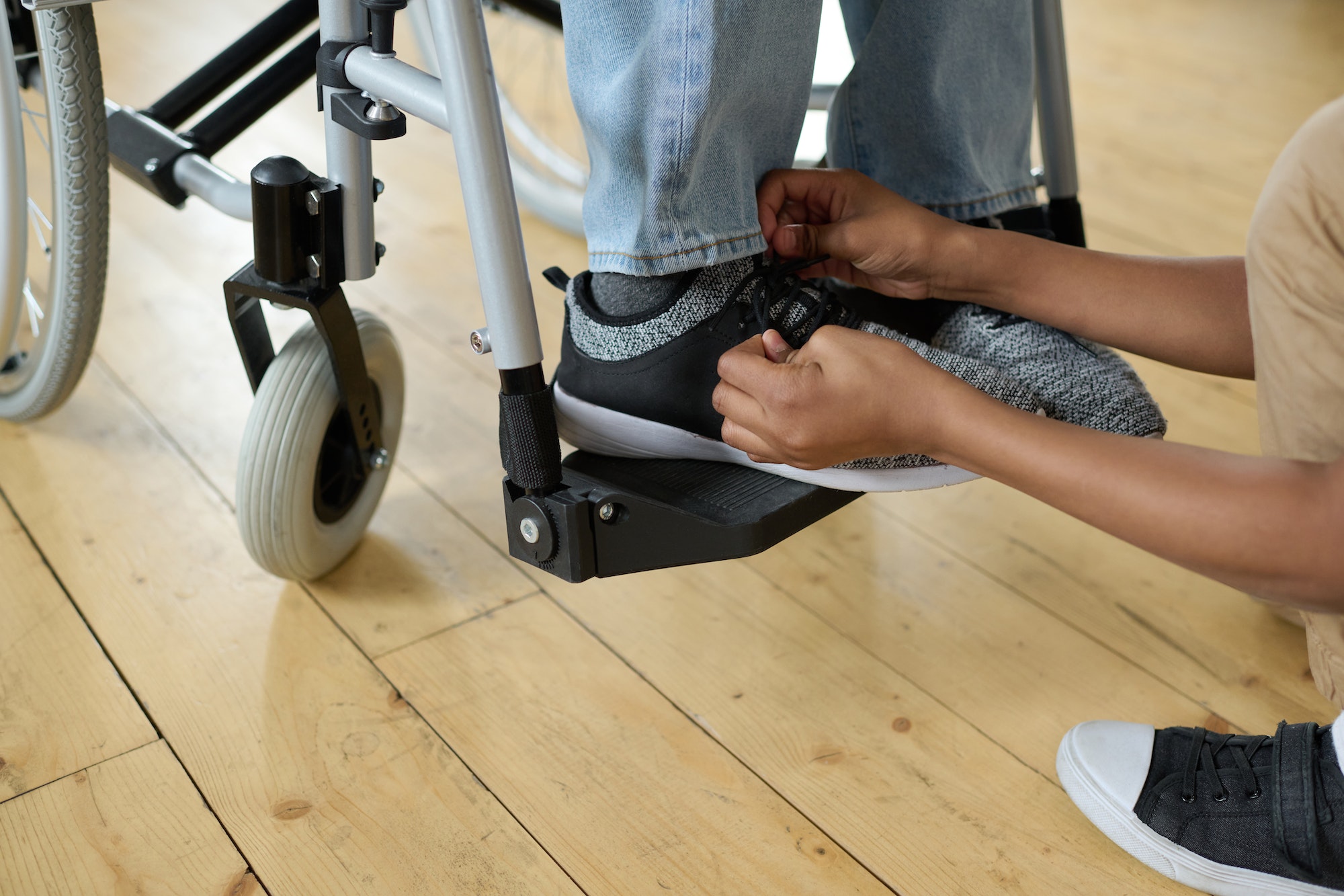 Person in wheelchair having shoes tied